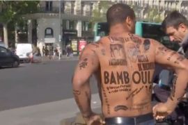 ناشط فرنسي استخدام جسده كلوحة دعائية مغطاة بوشوم مؤقتة تحمل إهانات عنصرية للاحتجاج على مرشحة اليمين المتطرف لوبان