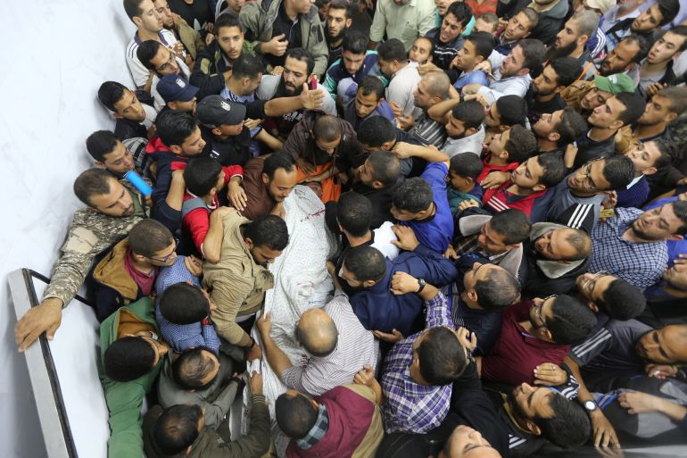 فلسطينيون يحملون جثامين شهداء في قطاع غزة