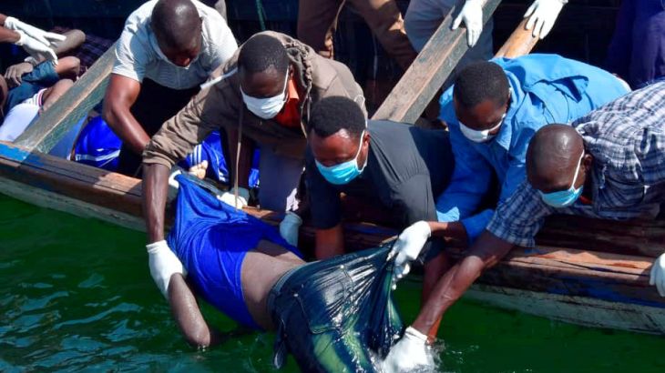 عمال الإنقاذ ينتشلون جثة رجل من الماء بعد انقلاب عبارة في بحيرة فيكتوريا
