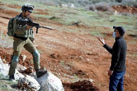 جندي إسرائيلي يوجه سلاحه نحو فلسطيني أثناء احتجاجات سابقة في الضفة الغربية