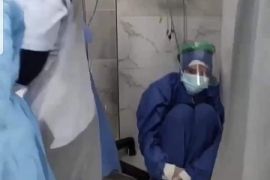 ممرضة تجلس على الأرض في حالة صدمة بعد وفاة المرضى