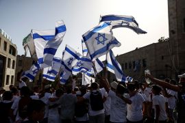 Israeli dance and sing while they hold Israeli national flags at a square outside Jerusalem's Old city