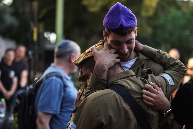 بكاء جنديين إسرائيليين خلال جنازة زميل لهما قضى في الهجوم الأخير (رويترز)