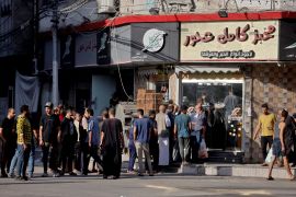 فلسطينيون أمام مخبز في غزة وسط الغارات الجوية الإسرائيلية (الفرنسية)