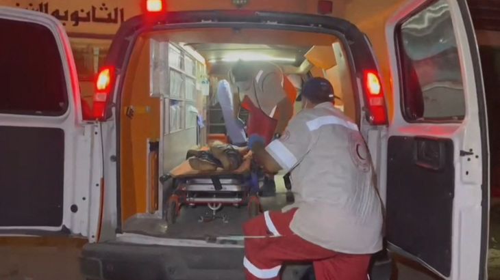 مسعفون يحملون شابا مصابا إلى سيارة إسعاف في منطقة الصفطاوي شمال مدينة غزة (الفرنسية)