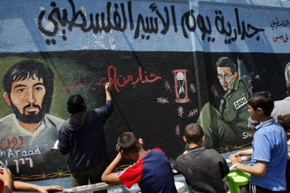 لوحة جدارية تصور الجندي الإسرائيلي الأسير السابق جلعاد شاليط (على اليمين) والطيار الإسرائيلي المفقود رون أراد (على اليسار)، الذي تم أسره بعد تحطم طائرته المقاتلة في لبنان عام 1986