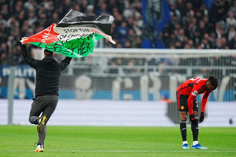 مشجع يقتحم مباراة في دوري الأبطال ويرفع العلم الفلسطيني