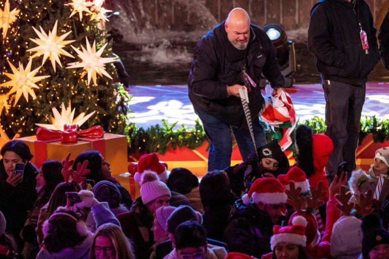 ضابط أمن ينزع الكوفية من أحد الحاضرين أثناء إضاءة شجرة عيد الميلاد بمركز روكفلر في نيويورك