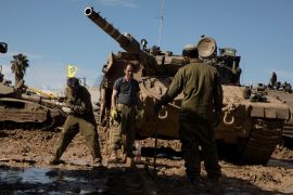 جنود إسرائيليون يصلحون مسارات دبابة بالقرب من الحدود مع غزة (غيتي)