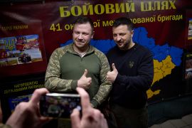 الرئيس الأوكراني فولوديمير زيلينسكي يقف لالتقاط صورة مع جندي أوكراني وسط الهجوم الروسي على البلاد (رويترز)