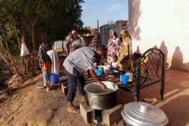 عائلات سودانية نازحة تنتظر الحصول على الطعام من مطبخ خيري (رويترز)