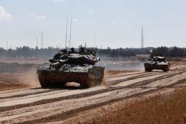جنود إسرائيليون فوق الدبابات بالقرب من حدود قطاع غزة (رويترز)