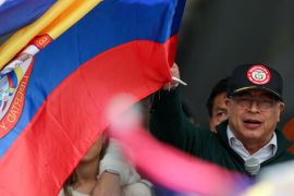 رئيس كولومبيا غوستافو بيترو يلوح بعلم بلاده خلال الكلمة (رويترز)